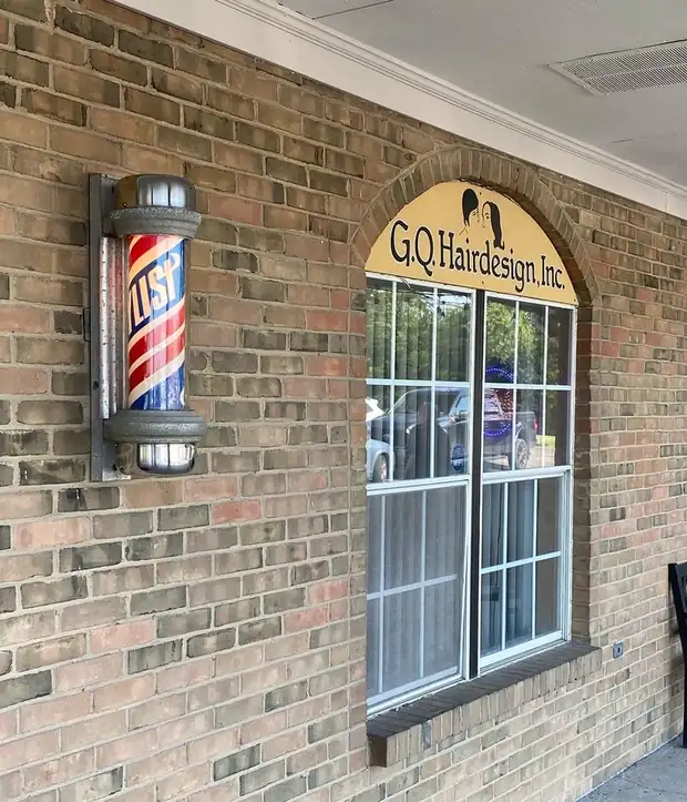 The GQ Hairdesign storefront on South Main Street, with the lit barber pole beside the arched shop sign