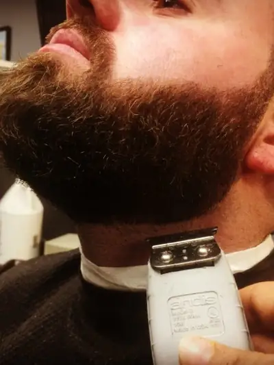 A beard being lined up with a trimmer at GQ Hair Design
